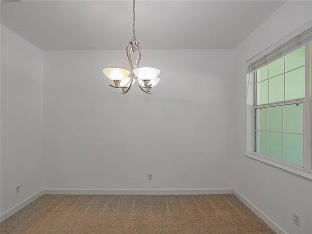 a view of a room with a window and chandelier fan