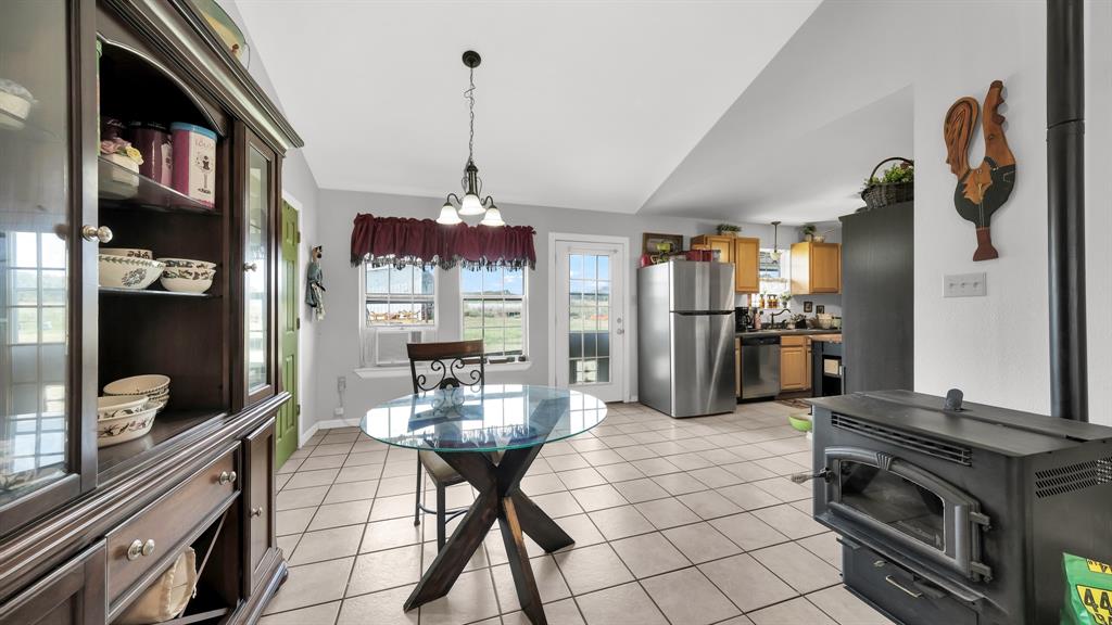 11500 Bowden Road Lipan, TX 76462 - Photo 21 of 32 a kitchen with kitchen island granite countertop a stove and a refrigerator