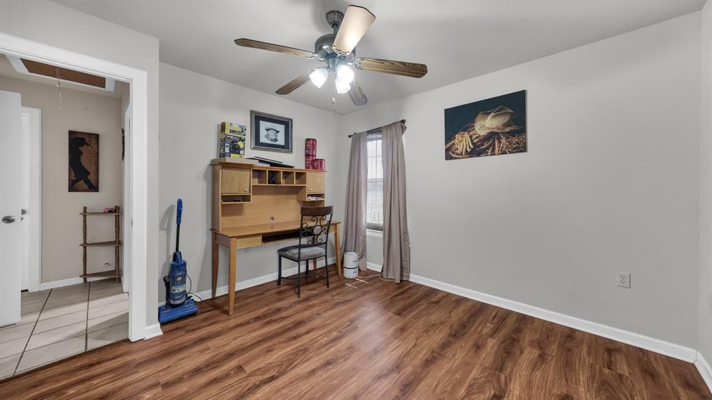 11500 Bowden Road Lipan, TX 76462 - Photo 27 of 32 a view of a livingroom with wooden floor and a ceiling fan