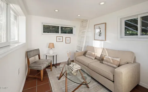 a living room with furniture a flat screen tv and a window