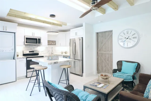 a kitchen with a dining table chairs and a refrigerator