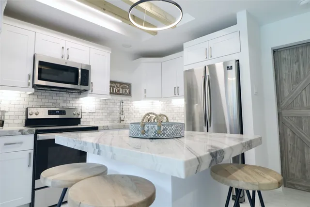 a kitchen with stainless steel appliances a refrigerator and a stove top oven