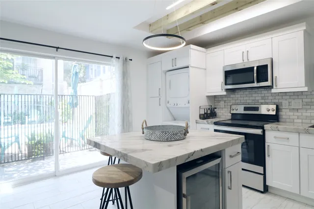 a kitchen with stainless steel appliances granite countertop a stove a sink a microwave a dining table and chairs