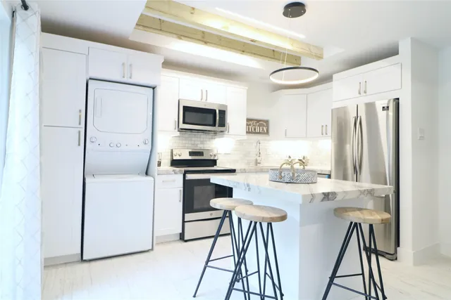 a kitchen with stainless steel appliances a refrigerator and a stove top oven