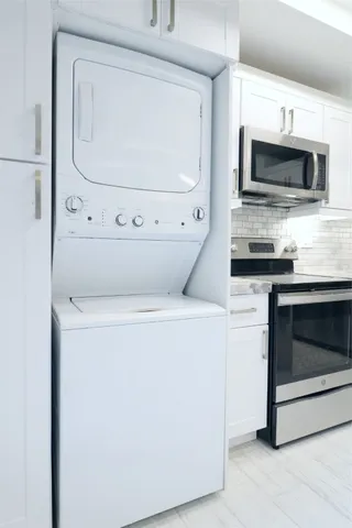 a kitchen with stainless steel appliances granite countertop a dining table and chairs
