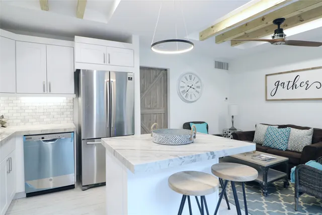 a kitchen with stainless steel appliances granite countertop a sink a stove a microwave a refrigerator and cabinets