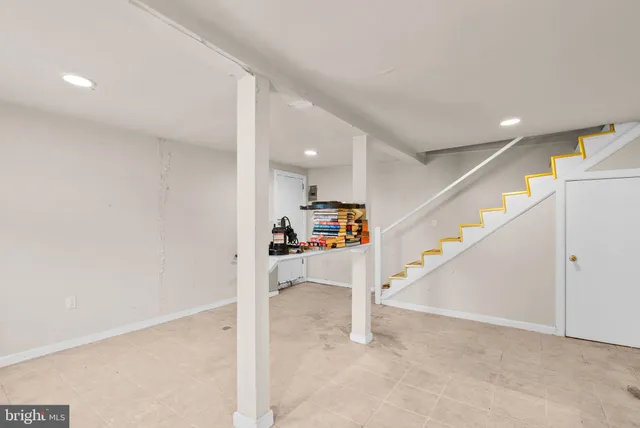 a living room with furniture and a refrigerator