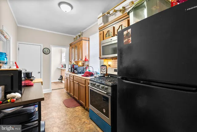 a kitchen with stainless steel appliances granite countertop a refrigerator and a stove top oven