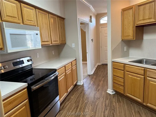 a kitchen with granite countertop wooden floors and stainless steel appliances