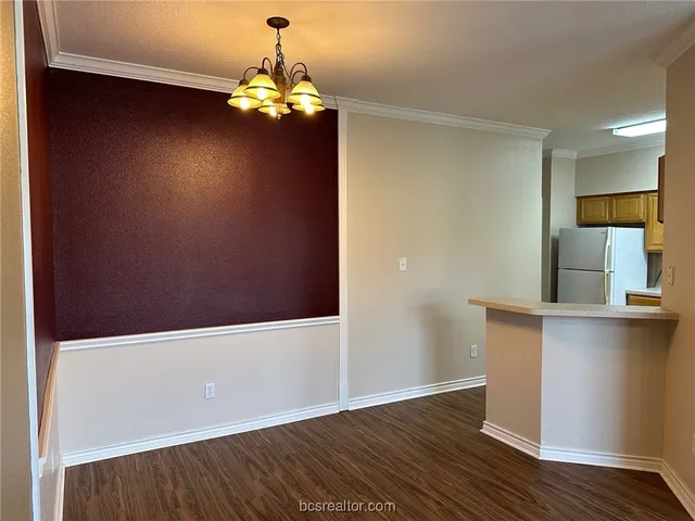 a room with wooden floors and chandelier