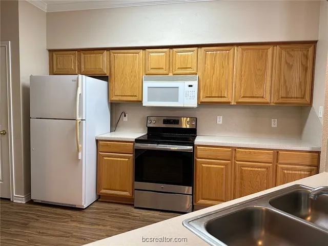 a kitchen with a refrigerator sink and cabinets