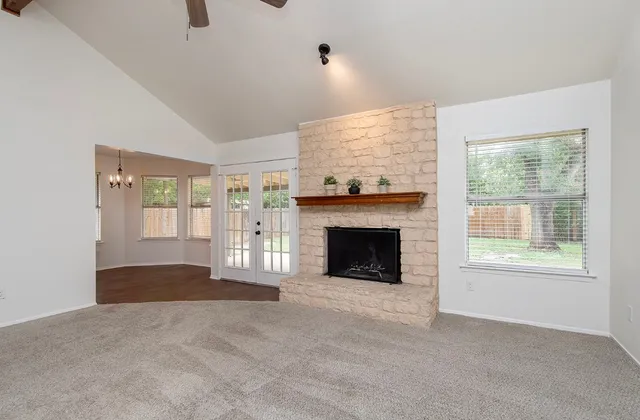 a view of an empty room with a fireplace and a window