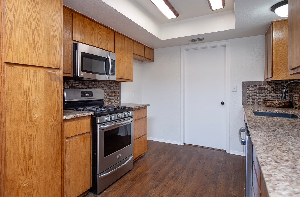 910 Garden View Drive Georgetown, TX 78628 - Photo 10 of 28 a kitchen with stainless steel appliances granite countertop a stove a microwave and a refrigerator
