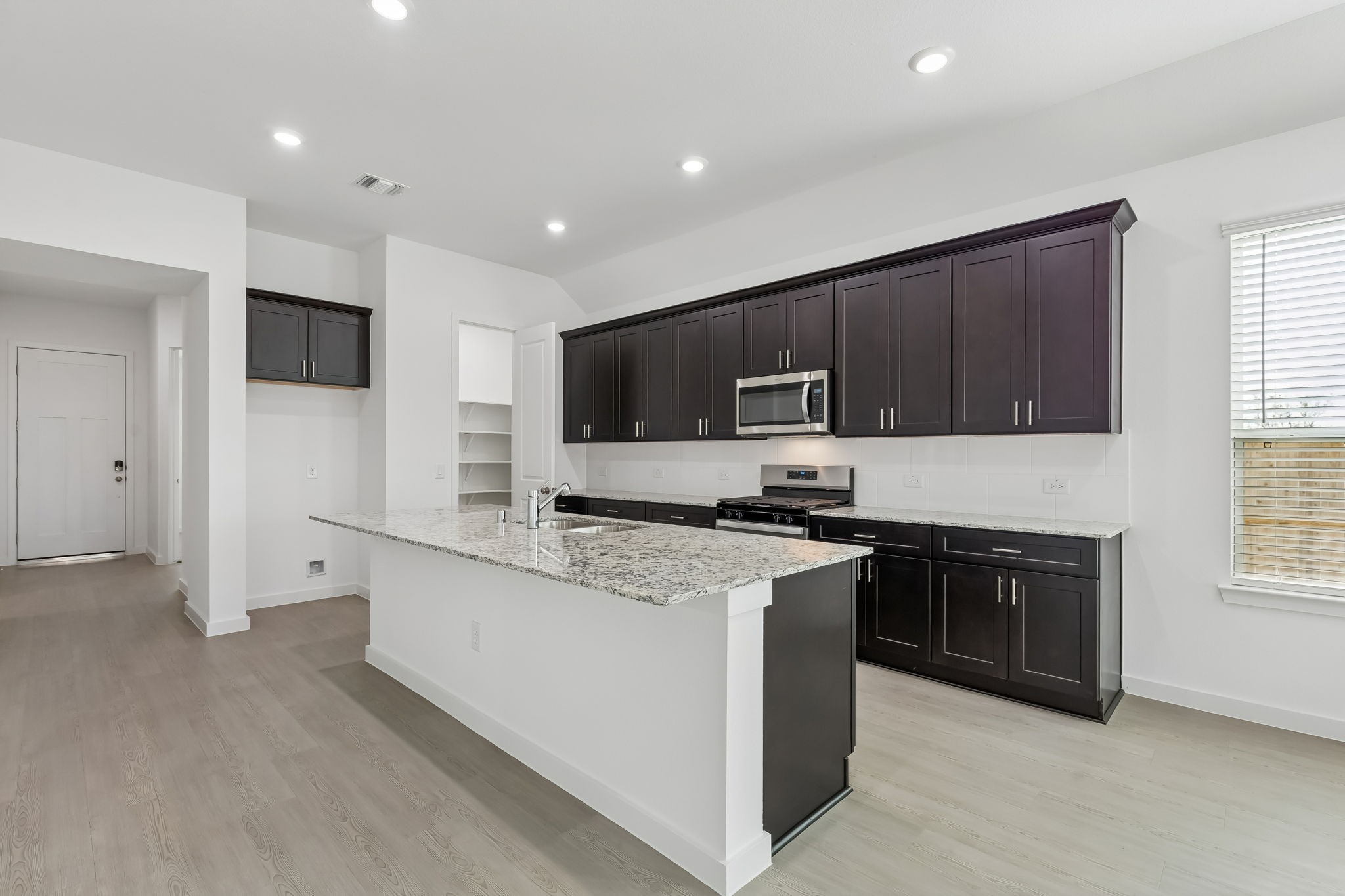 6703 Alejandro Place Cove, TX 77523 - Photo 7 of 30 a large kitchen with stainless steel appliances granite countertop a stove top oven a sink dishwasher and a refrigerator with wooden cabinets
