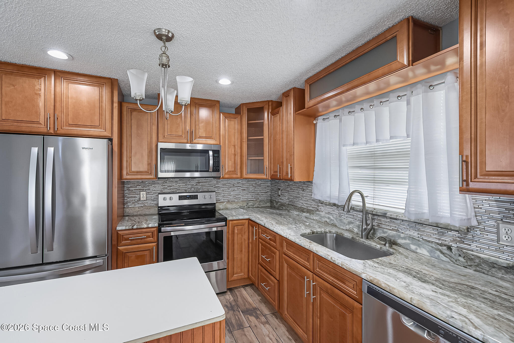 865 Dewberry Terrace Northeast Palm Bay, FL 32905 - Photo 3 of 29 a kitchen with kitchen island granite countertop a sink stainless steel appliances and cabinets