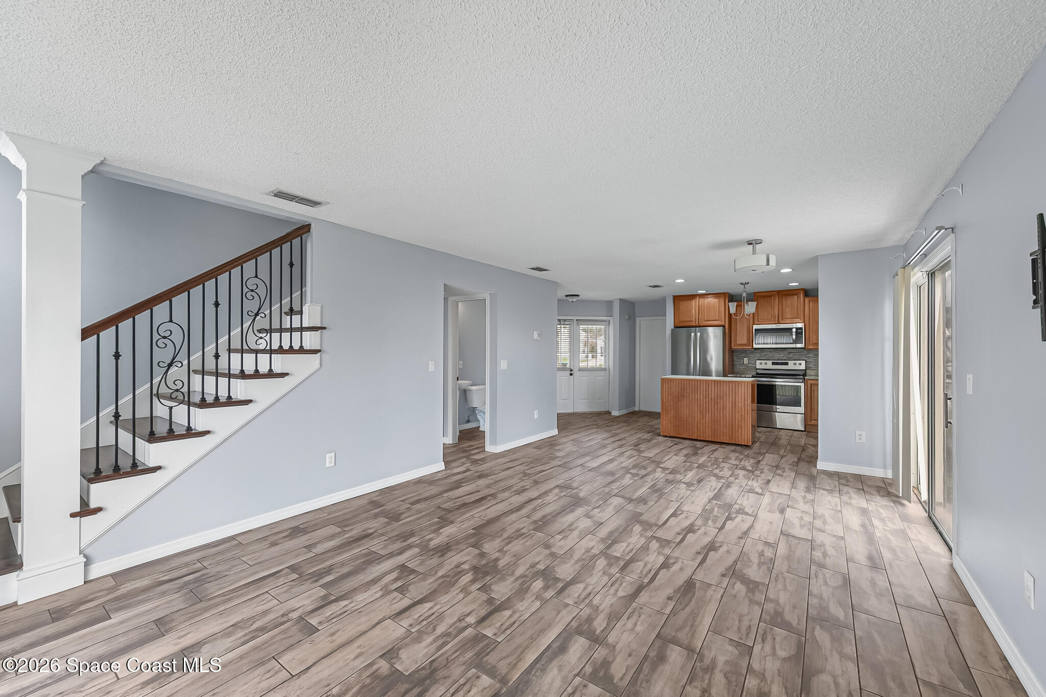 865 Dewberry Terrace Northeast Palm Bay, FL 32905 - Photo 4 of 29 a view of a room with wooden floor and stairs