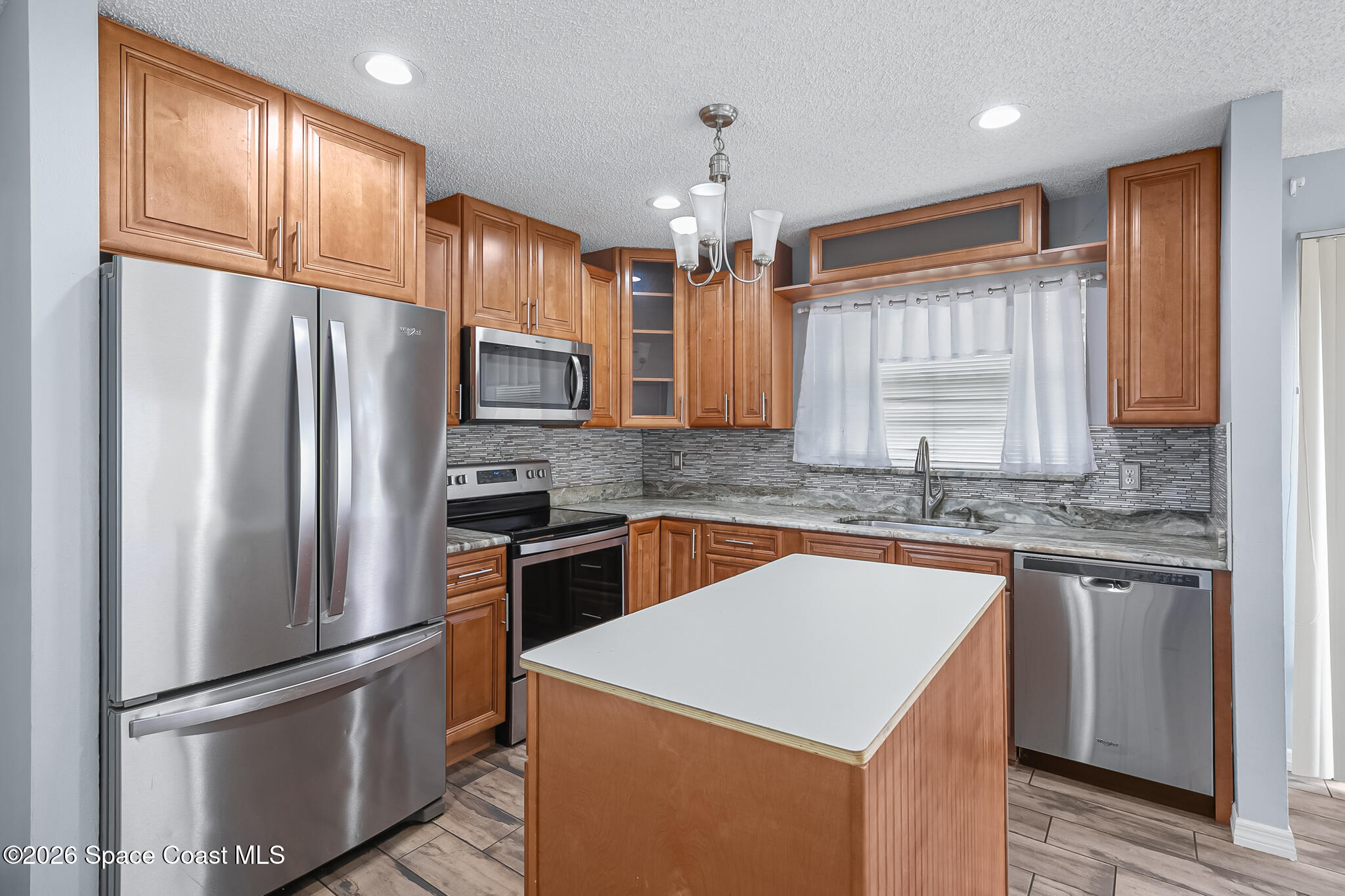 865 Dewberry Terrace Northeast Palm Bay, FL 32905 - Photo 5 of 29 a kitchen with stainless steel appliances granite countertop a refrigerator a sink a stove and a refrigerator