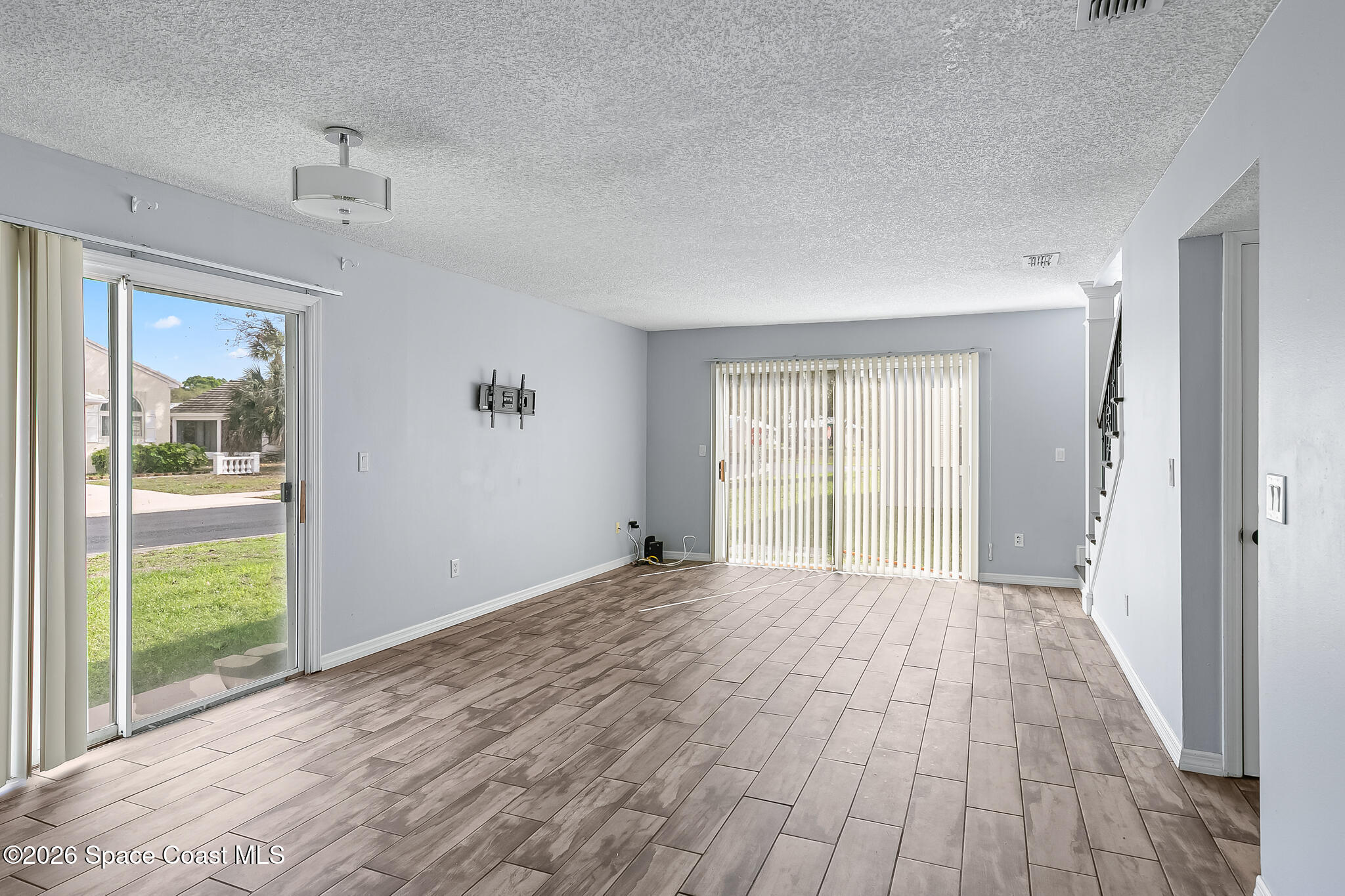 865 Dewberry Terrace Northeast Palm Bay, FL 32905 - Photo 7 of 29 a view of an empty room with wooden floor and a window