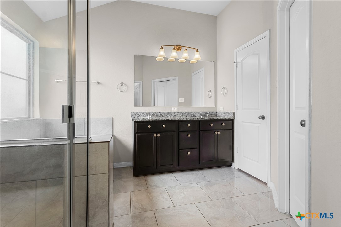 3615 Addison Street Killeen, TX 76542 - Photo 27 of 47 a spacious bathroom with a granite countertop sink a mirror and a vanity