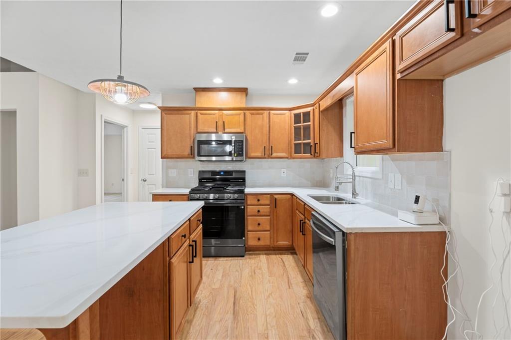 1227 Al Roberts Road Senoia, GA 30276 - Photo 19 of 43 a kitchen with stainless steel appliances granite countertop a sink stove and refrigerator