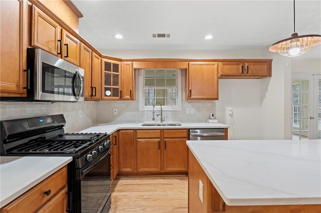 1227 Al Roberts Road Senoia, GA 30276 - Photo 21 of 43 a kitchen with stainless steel appliances granite countertop a stove and a sink