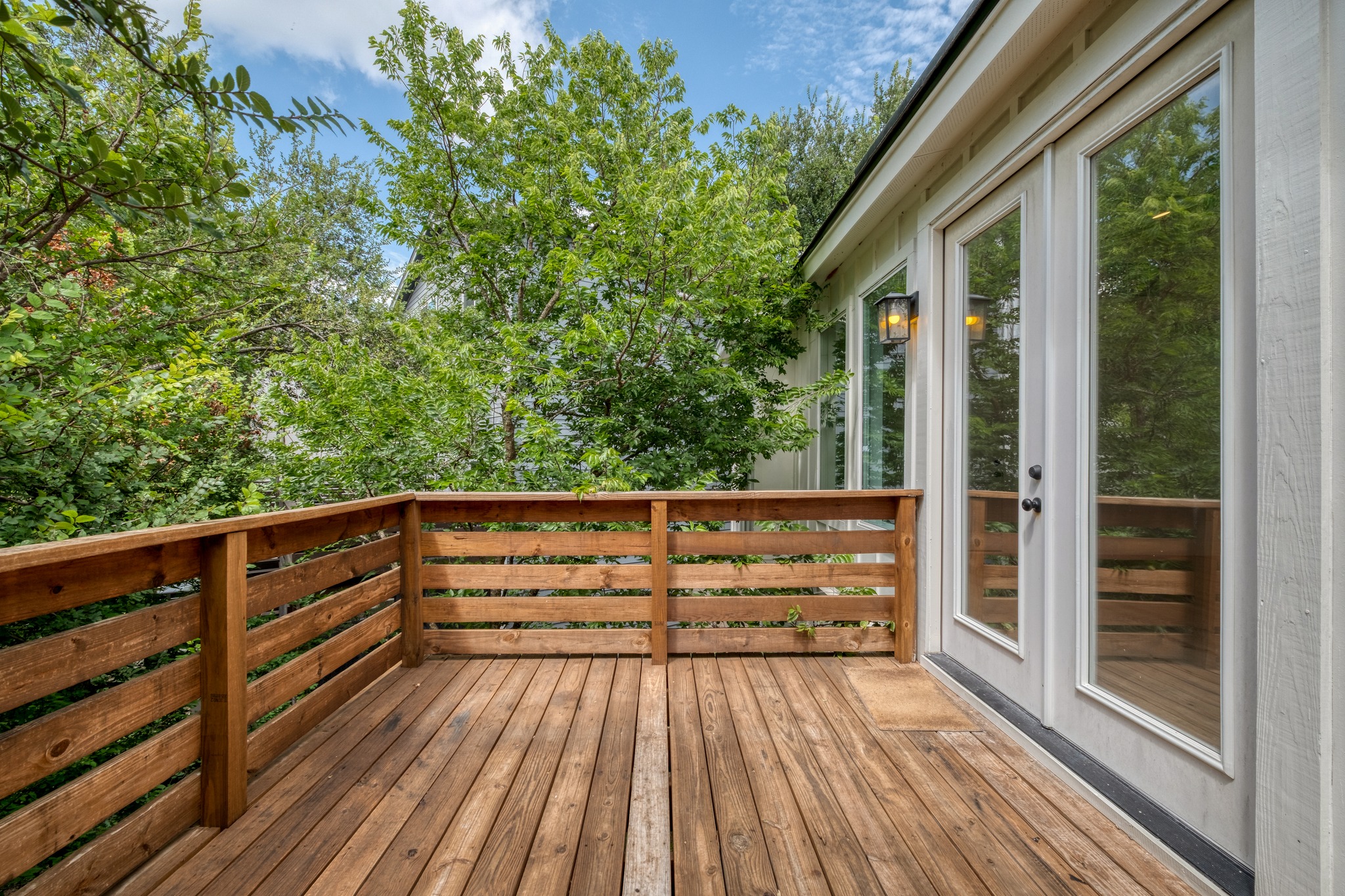 5211 Rob-Scott Street Austin, TX 78721 - Photo 23 of 24 A spacious wood-planked deck with a sturdy railing overlooks a verdant landscape, offering an inviting outdoor retreat.