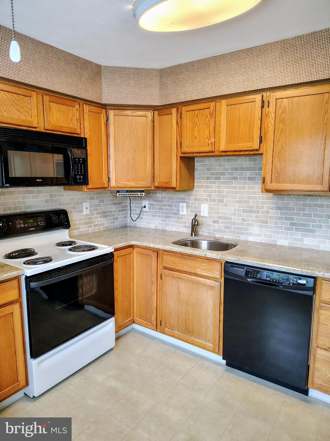 2803 Sweetleaf Terrace Mount Laurel, NJ 08054 - Photo 7 of 13 a kitchen with granite countertop a stove a sink and a microwave