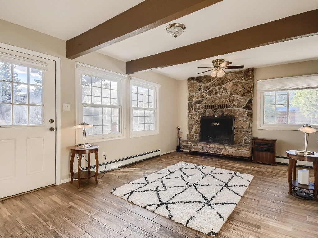 402 Alpine Road Dillon, CO 80435 - Photo 5 of 21 an empty room with windows a fireplace and wooden floor
