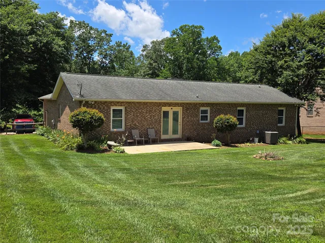 a front view of a house with a garden and trees