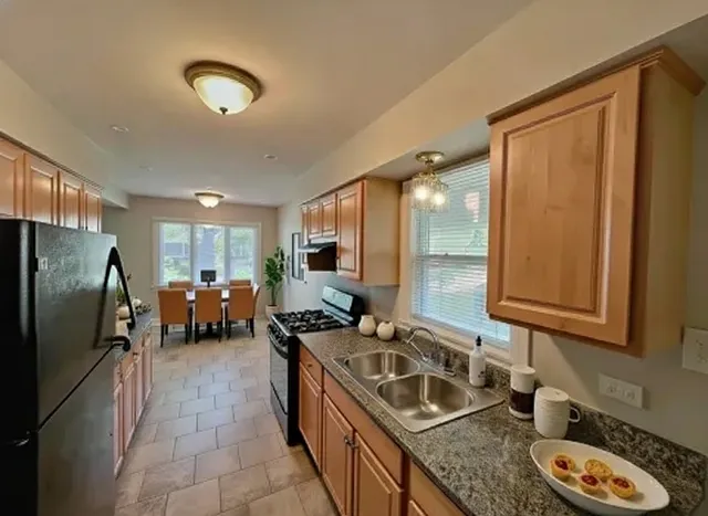 a kitchen with sink refrigerator and cabinets