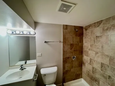 a bathroom with a sink shower and a toilet