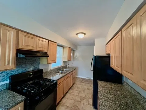 a kitchen with granite countertop a stove and a refrigerator