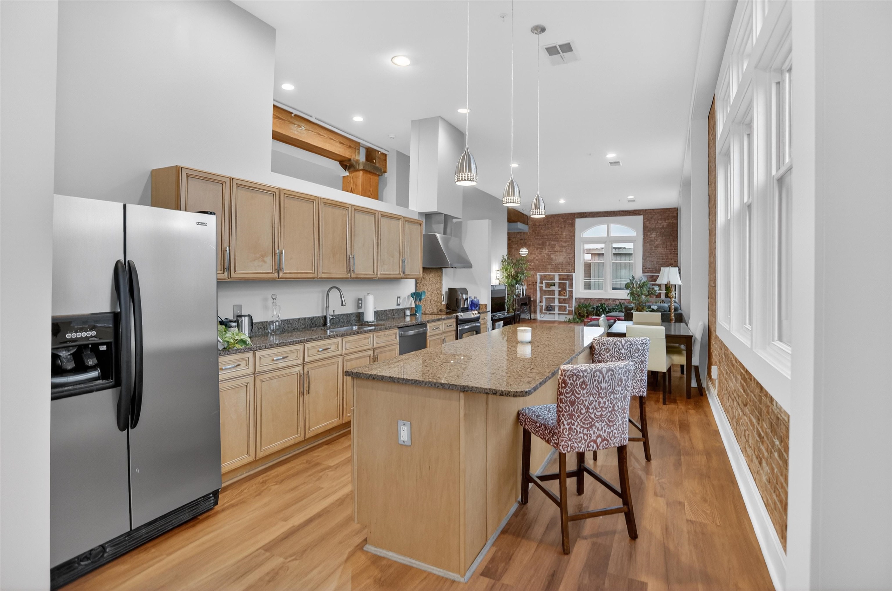 435 South Front Street, Unit 307 Memphis, TN 38103 - Photo 4 of 40 a kitchen with stainless steel appliances granite countertop a refrigerator a sink dishwasher a stove and a microwave oven with wooden floor