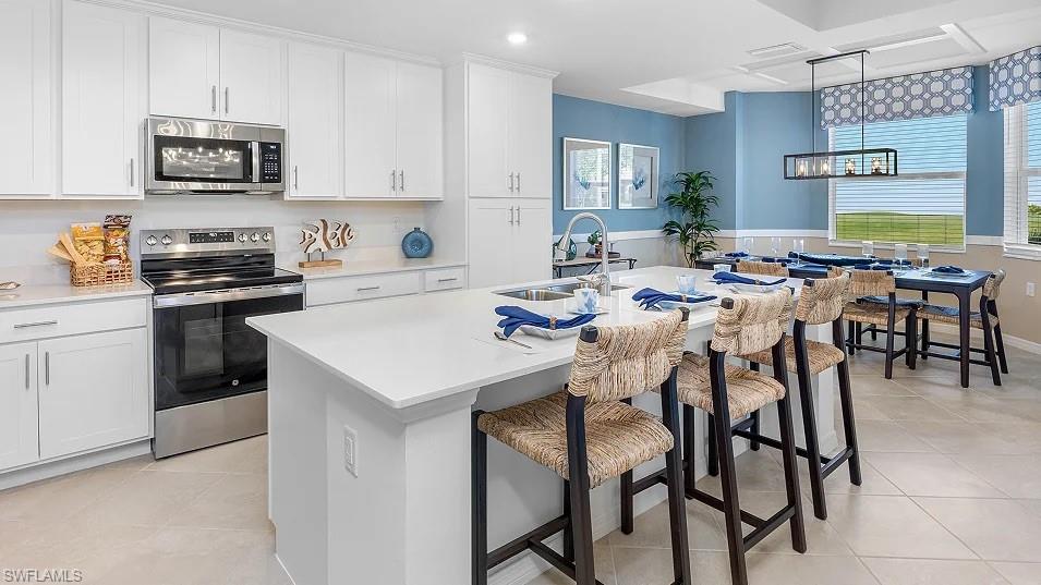5491 Double Eagle Circle, Unit 3723 Ave Maria, FL 34142 - Photo 1 of 42 Kitchen with appliances with stainless steel finishes, a breakfast bar, plenty of natural light, pendant lighting, and recessed lighting