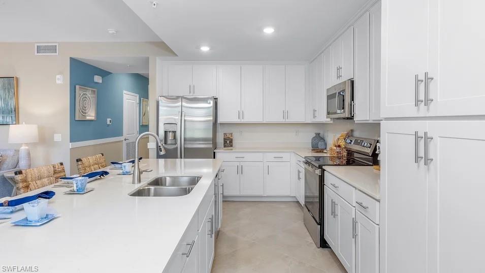 5491 Double Eagle Circle, Unit 3723 Ave Maria, FL 34142 - Photo 3 of 42 Kitchen featuring appliances with stainless steel finishes, white cabinets, light stone countertops, and recessed lighting