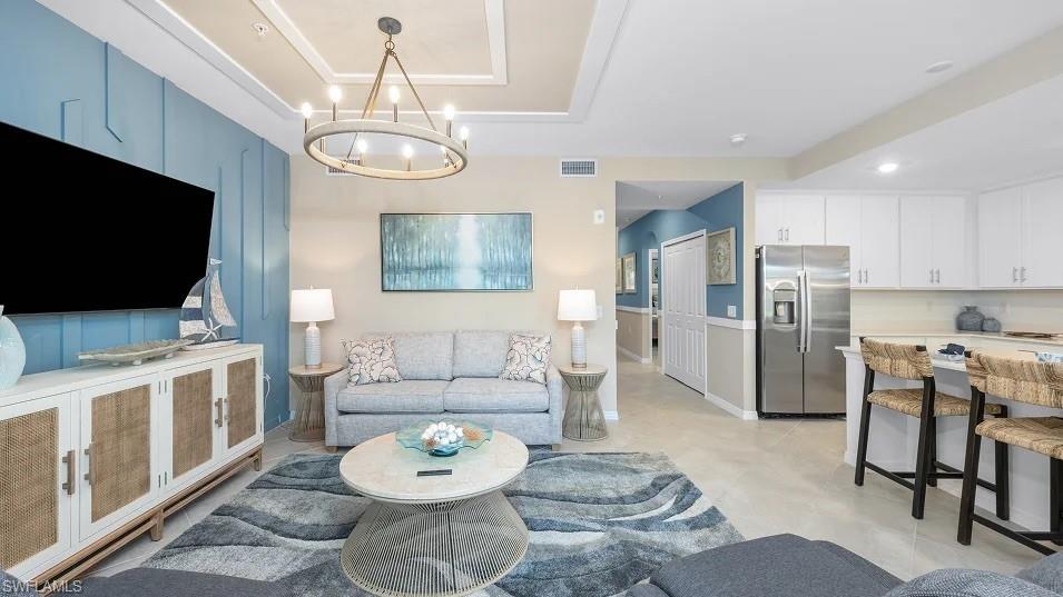 5491 Double Eagle Circle, Unit 3723 Ave Maria, FL 34142 - Photo 5 of 42 Living area with a tray ceiling and a chandelier