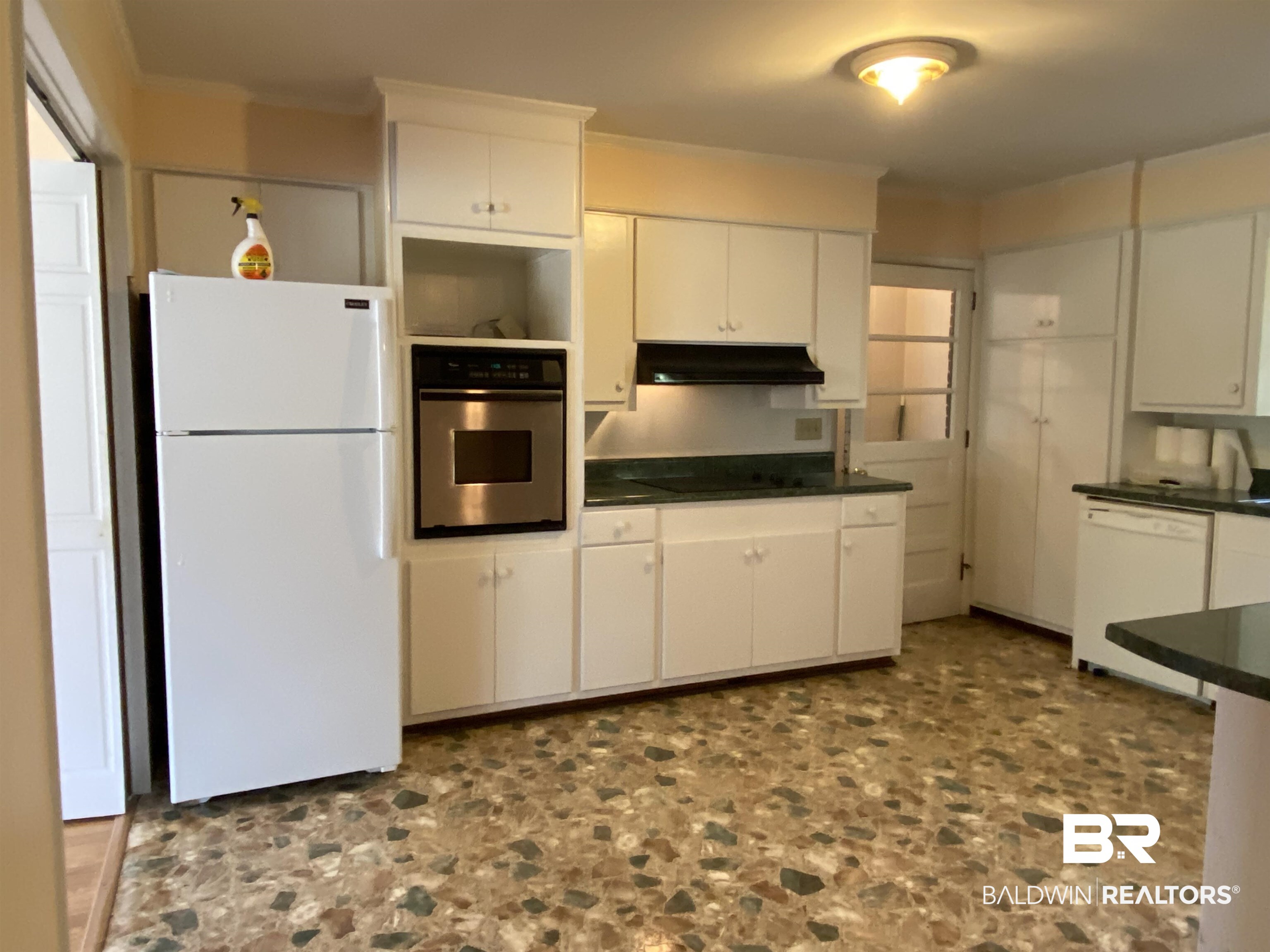 106 Terry Drive Brewton, AL 36426 - Photo 7 of 25 Kitchen with dark countertops, white appliances, white cabinetry, and under cabinet range hood