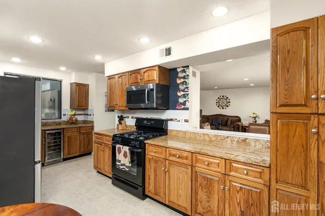 a kitchen with stainless steel appliances granite countertop a stove refrigerator sink and microwave