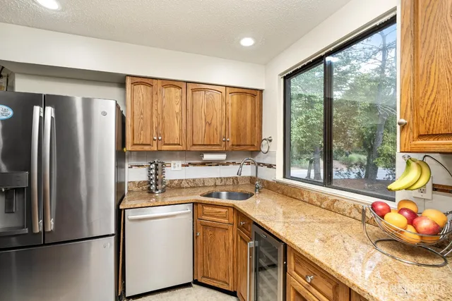 a kitchen with a sink a refrigerator and window