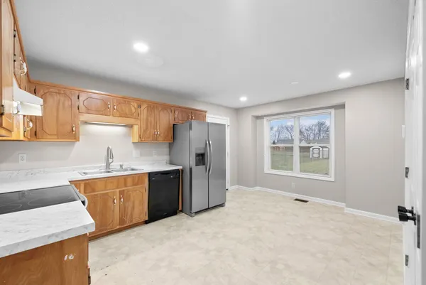 a large kitchen with stainless steel appliances granite countertop a sink stove and refrigerator