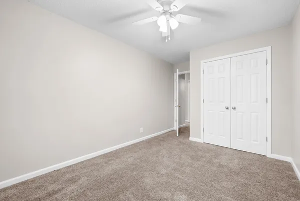 an empty room with a chandelier fan