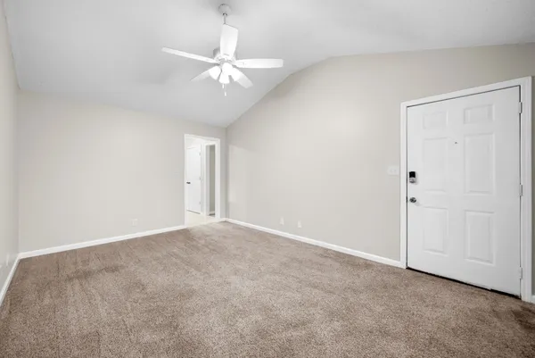 an empty room with a chandelier fan and closet area