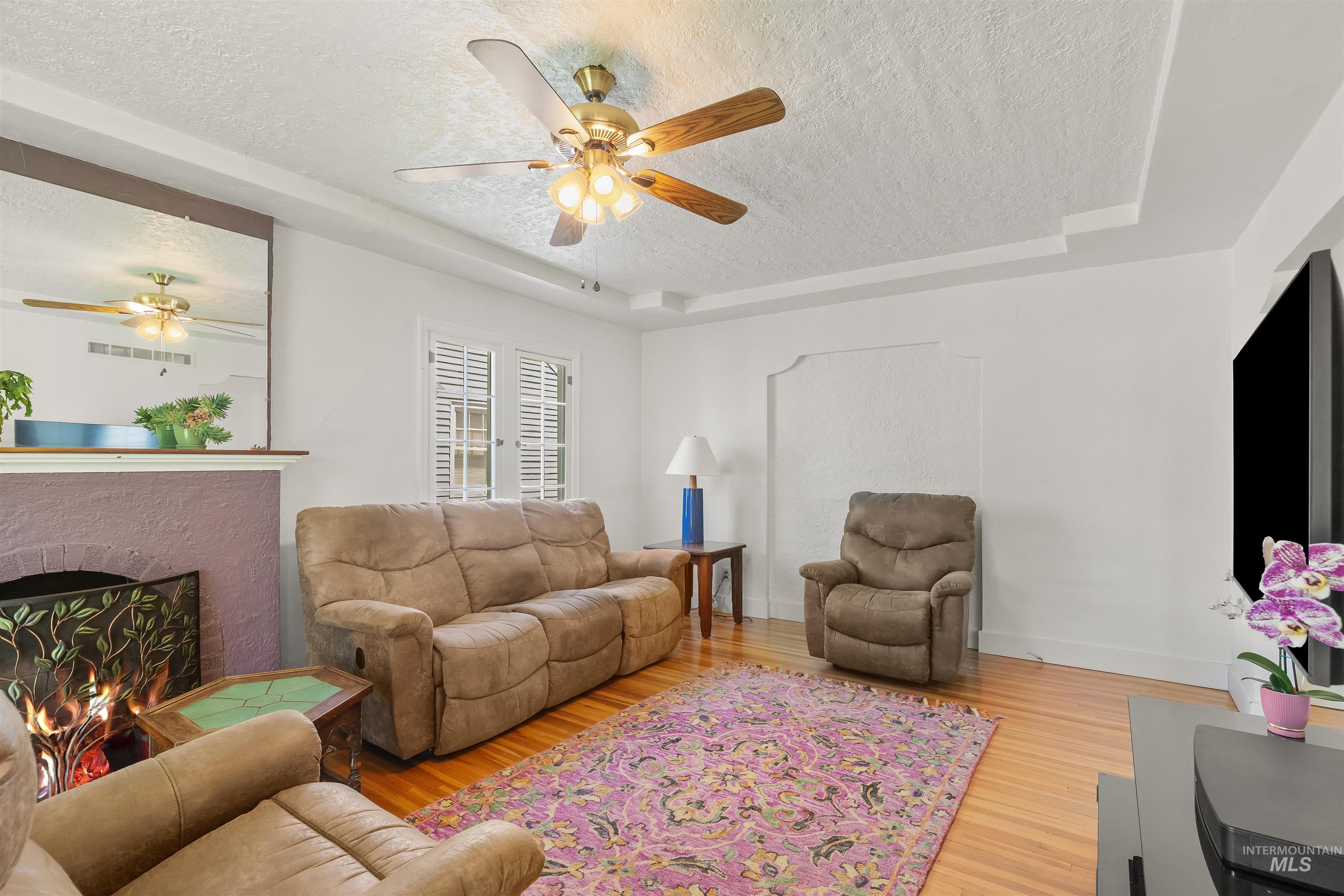 924 N Street Lewiston, ID 83501 - Photo 12 of 46 Spacious interior featuring a decorative fireplace with a custom screen, hardwood flooring, and a ceiling fan