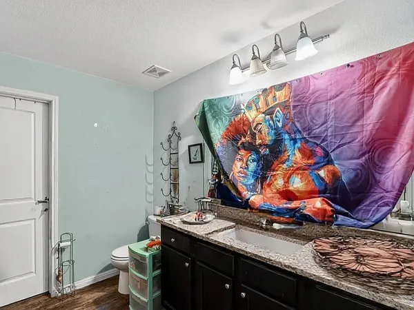 a view of a bedroom with a sink and wooden floor
