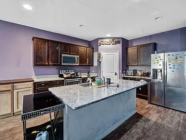 a kitchen with stainless steel appliances granite countertop a sink stove and refrigerator