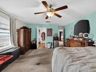 a bedroom with bed and wooden floor