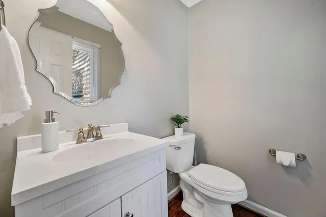 a bathroom with a sink mirror and toilet