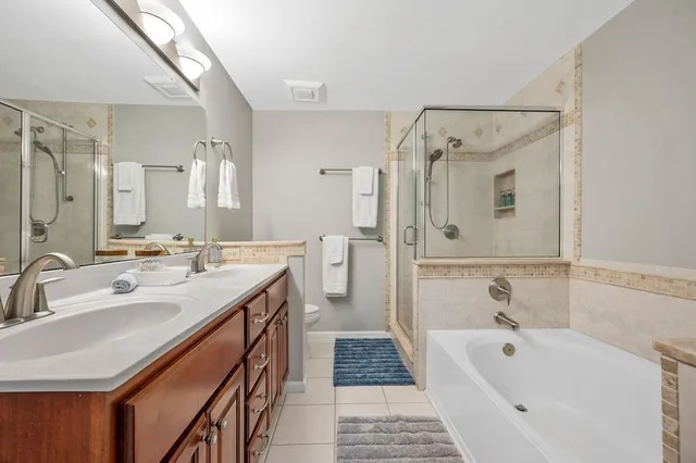 a spacious bathroom with a tub sink shower and mirror