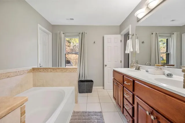 a bathroom with a tub sink and mirror