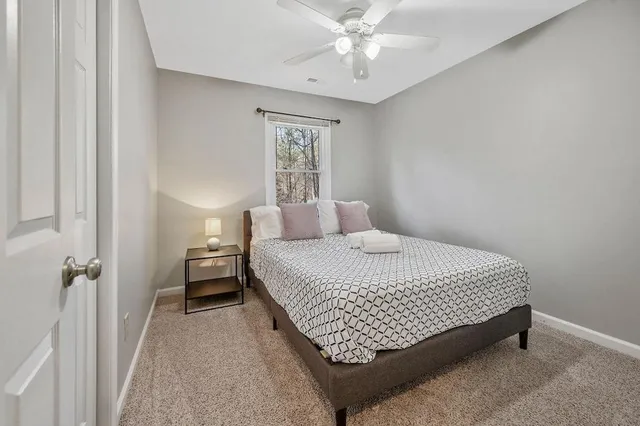 a bedroom with a bed lamp and a window
